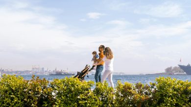 A baby with eczema on cheeks lying on a white blanket looking up with curiosity