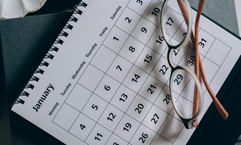 A young child playing with colorful building blocks on a carpeted floor in a bright room