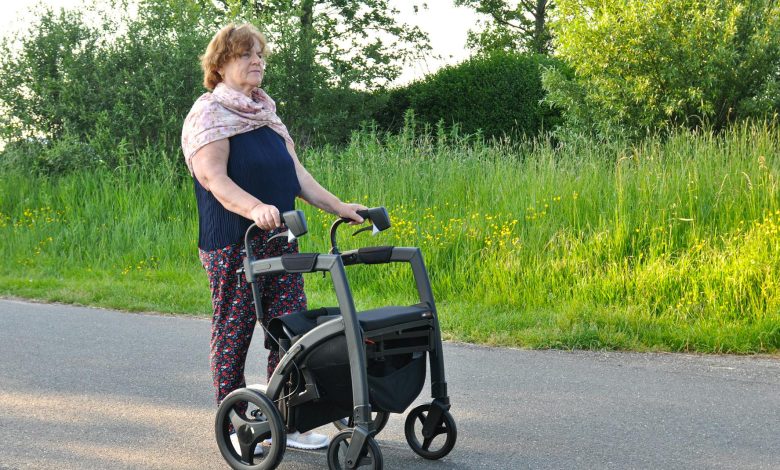 Elderly man with a cane walking in a park, highlighting subtle signs of Parkinson's disease beyond tremors